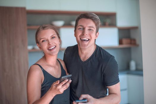cheerful young couple reading email on smartphone. people and technology