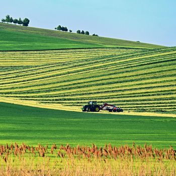 Tractor in the field. Beautiful spring landscape in the countryside in the Czech Republic. Concept for agriculture and nature.