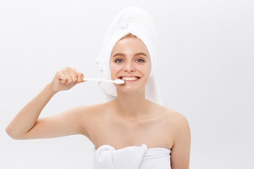 portrait of attractive caucasian smiling woman isolated on white studio shot head and shoulders face skin hand with tooth brush.