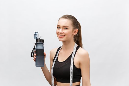 Beautiful young woman with measuring tape and bottle of water on white background. Diet concept.