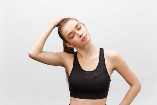 Young sporty beautiful woman stretching arms on side. Isolated over white background.