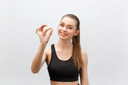 Supplements, Sports, Vitamins, Diet, Nutrition, Healthy Eating, Lifestyle. Close up of smiling fitness woman taking pill with cod liver oil Omega-3 , vitamin D, E, A fish oil capsules.