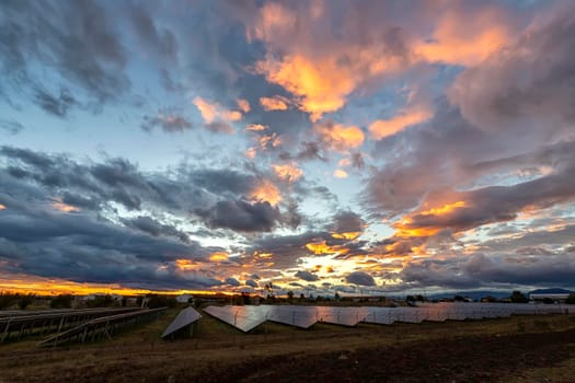Amazing colorful sky after sunset over solar panels, with reflection