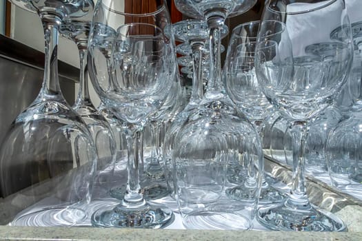 Rows of empty wine glasses close up. Glass goblets on the white table. Restaurant bar concept