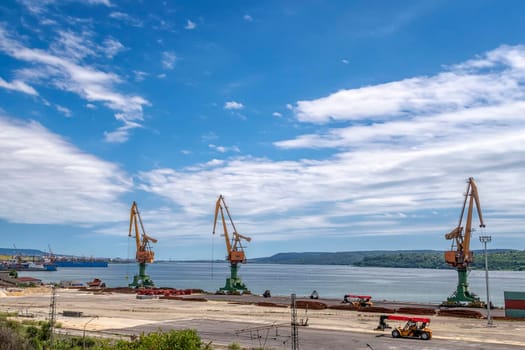 Port cranes ready to load containers from cargo ships. horizontal view