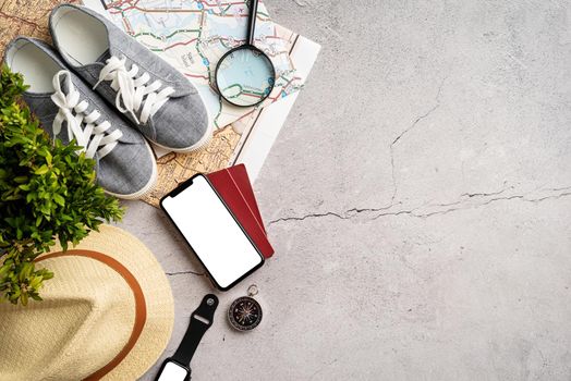 travel plan, trip and vacation, technology. Top view travel accessories with shoes, map, smartphone with mockup screen, hat. Copy space