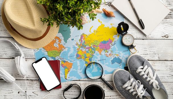 travel plan, trip and vacation, technology. Top view travel accessories with shoes, map, smartphone with mockup screen, hat. Copy space