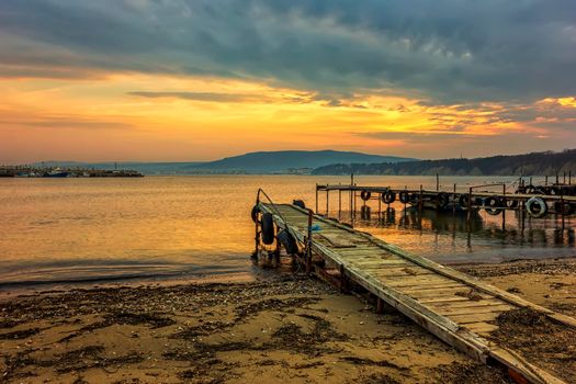 Amazing idylic sunset or sunrise at a shore with wooden piers