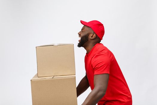 Portrait of delivery african american man in red shirt. he lifting heavy weight boxes against having a isolated on the white background