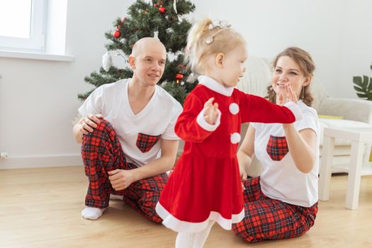 Toddler child with cochlear implant decorating christmas tree deafness and innovating medical technologies for hearing aid