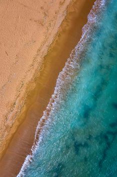 Top view aerial photo from drone to the beautiful sea and yellow sand. Vertical view