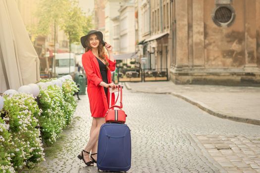 Smiling girl walking on the old street wearing hat and posing at the city in summer.