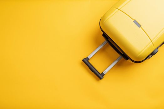 travel plan, trip and vacation, minimal. Top view yellow travel bag or suitcase on solid yellow background with copy space