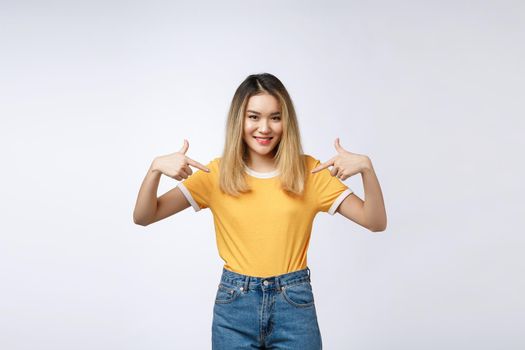Asian woman pointing finger to her shirt isolate over grey background