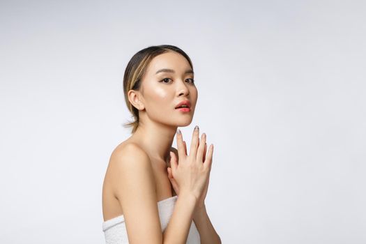 Sided portrait of Asian beautiful smiling girl with short hair showing her healthy skin on the isolated white background.