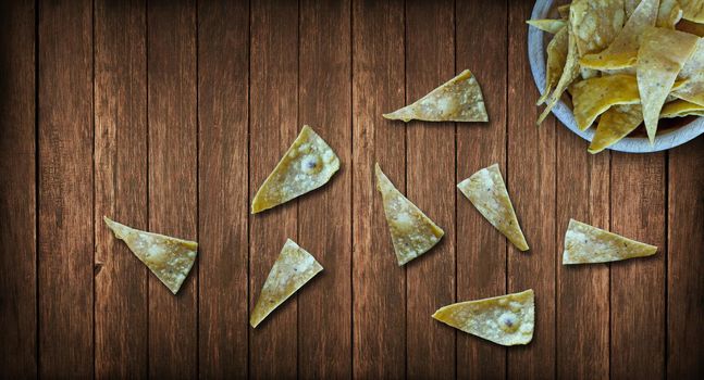 totopo tortilla chips bowl on a wooden background, old, grunge wood panels used as background