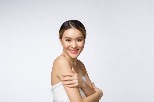 Sided portrait of Asian beautiful smiling girl with short hair showing her healthy skin on the isolated white background.