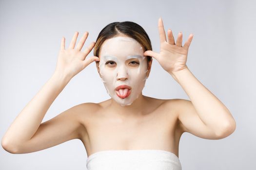 Spa, healthcare. Asian girl with a cosmetic mask isolate on white