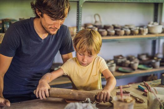 Father and son doing ceramic pot in pottery workshop.