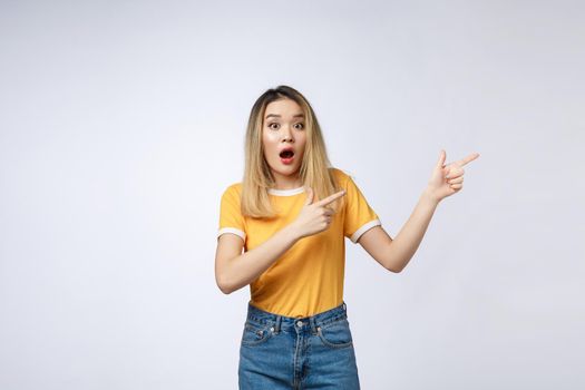 Smiling woman pointing finger on copy space. Isolated portrait on white