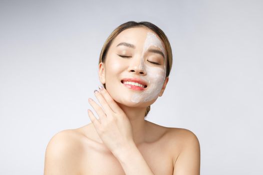 Charming pleasant woman applying cream on half face