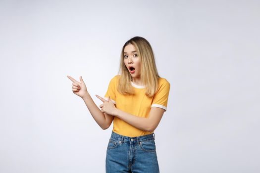 Smiling woman pointing finger on copy space. Isolated portrait on white