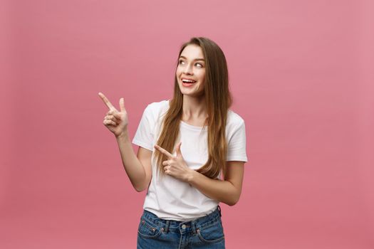 Woman pointing finger at camera and toothy smiling. Expression emotion and feelings concept. Studio shot, isolated on pink background.