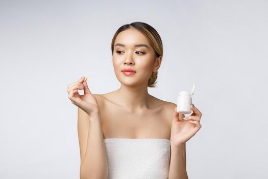 Healthy happy asian woman with pills in hand isolate over white background