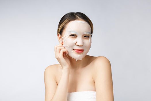 Spa, healthcare. Asian girl with a cosmetic mask isolate on white