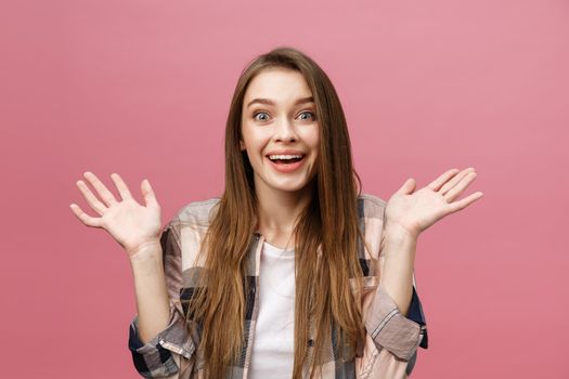 Surprised happy beautiful woman looking in excitement. Isolate over pink background and copy space