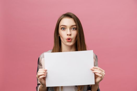 Young caucasian woman holding blank paper sheet over isolated background scared in shock with a surprise face,and excited with fear expression