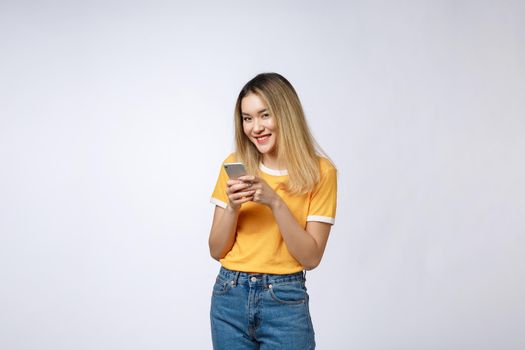 Woman look and texting with friend on mobile phone isolated over grey background