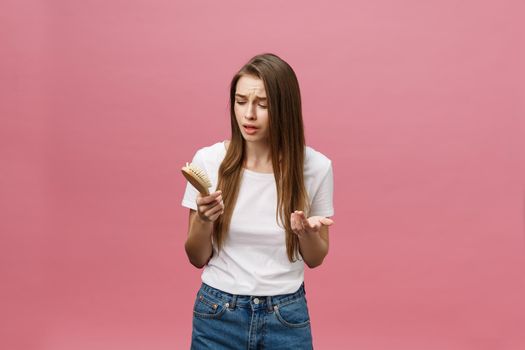 girl on a pink background with a comb for the hair, the hair problem.