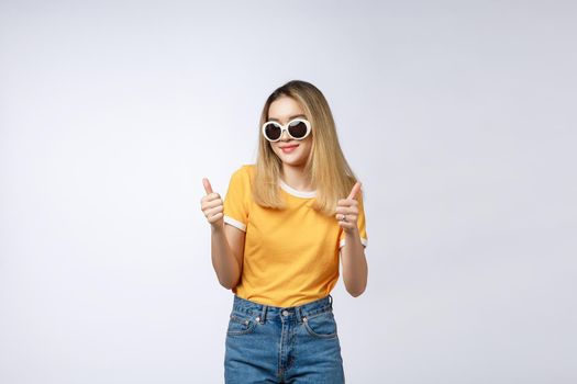 Portrait of a beautiful young asian woman showing thumbs up. Isolated on white background