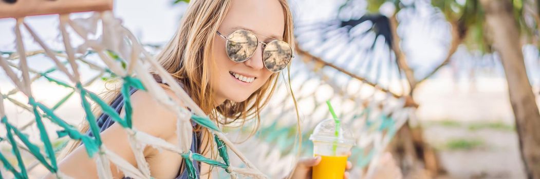 Young woman on the beach in a hammock with a drink. BANNER, LONG FORMAT