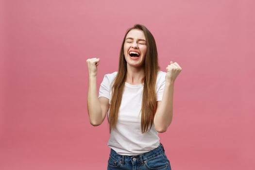 Happy successful young woman with smiling,shouting and celebrating success over pink background.