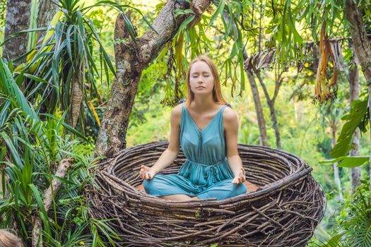 Bali trend, straw nests everywhere. Young tourist enjoying her travel around Bali island, Indonesia. Making a stop on a beautiful hill. Photo in a straw nest, natural environment. Lifestyle.