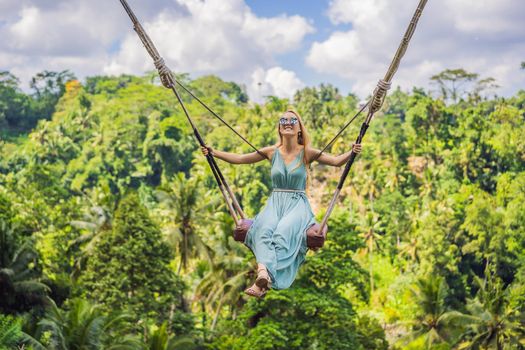 Young woman swinging in the jungle rainforest of Bali island, Indonesia. Swing in the tropics. Swings - trend of Bali.