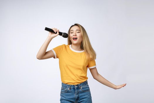 Beautiful asian woman sing a song to microphone, portrait studio on white background