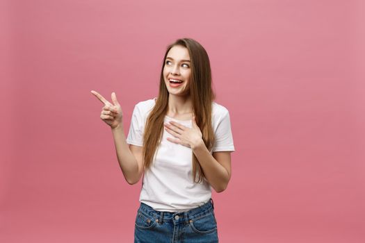 Woman pointing finger at camera and toothy smiling. Expression emotion and feelings concept. Studio shot, isolated on pink background.