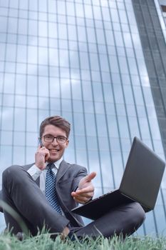 cheerful businessman speaks on his smartphone and points at you. photo with copy space