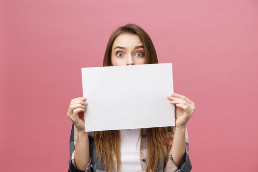 Young caucasian woman holding blank paper sheet over isolated background scared in shock with a surprise face,and excited with fear expression