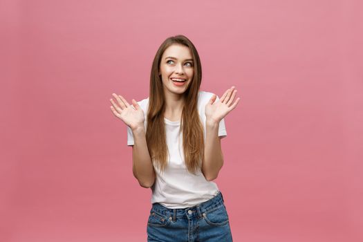 Surprised happy beautiful woman looking in excitement. Isolate over pink background and copy space