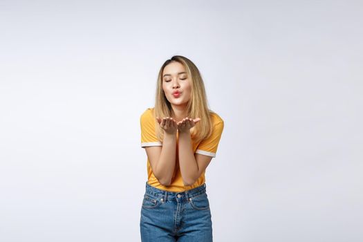 Beautiful young Asian woman blow a kiss isolated on white background