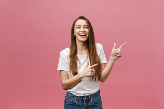 Woman pointing finger at camera and toothy smiling. Expression emotion and feelings concept. Studio shot, isolated on pink background.