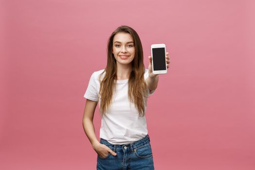 Photo of cheerful cute beautiful young woman chatting by mobile phone isolated over pink wall background