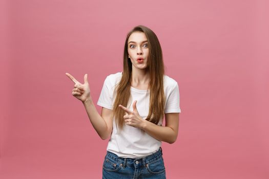 Woman pointing finger at camera and toothy smiling. Expression emotion and feelings concept. Studio shot, isolated on pink background.