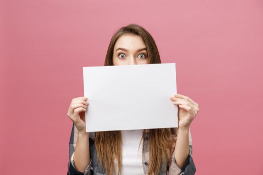 Young caucasian woman holding blank paper sheet over isolated background scared in shock with a surprise face,and excited with fear expression