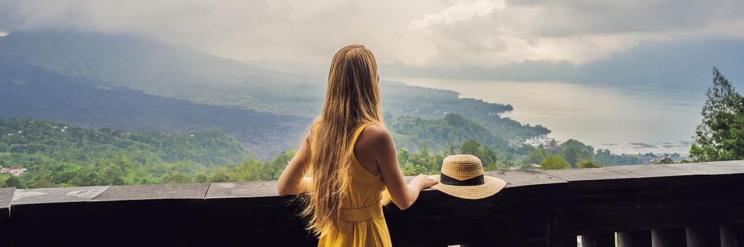 Woman traveler looking at Batur volcano. Indonesia. BANNER, LONG FORMAT