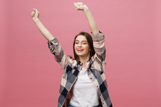 Happy successful young woman with smiling,shouting and celebrating success over pink background.